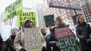 Activists hold signs calling for the closure of the Berks County migrant detention center during a Philadelphia rally.