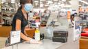 Esther Iglesias, a sales clerk in the shoe department at Boscov's at Plymouth Meeting Mall, wipes a counter.