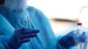 A nurse holds a nasopharyngeal swab and the sample tube during a coronavirus test.