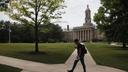 A person walks on the campus of Penn State Main in State College, Pa.