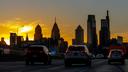 The sun sets behind City Hall and the Philadelphia skyline Dec. 3, 2021, photographed on southbound Interstate I-95, just north of Center City.